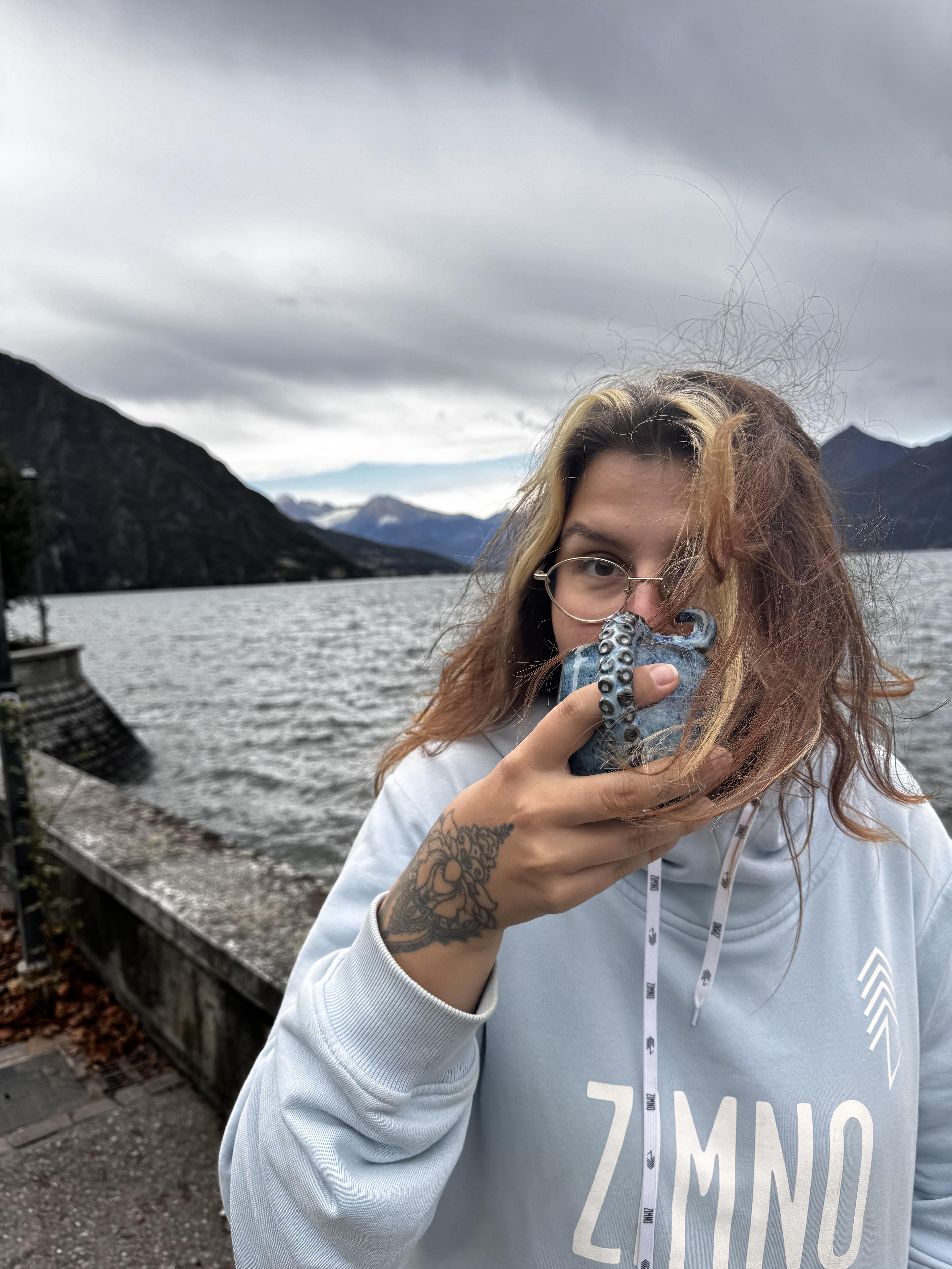 Alicja pijąca z kubka Kraken nad morzem