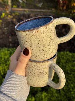 Kubki Piaskowe — para kubków w dłoni